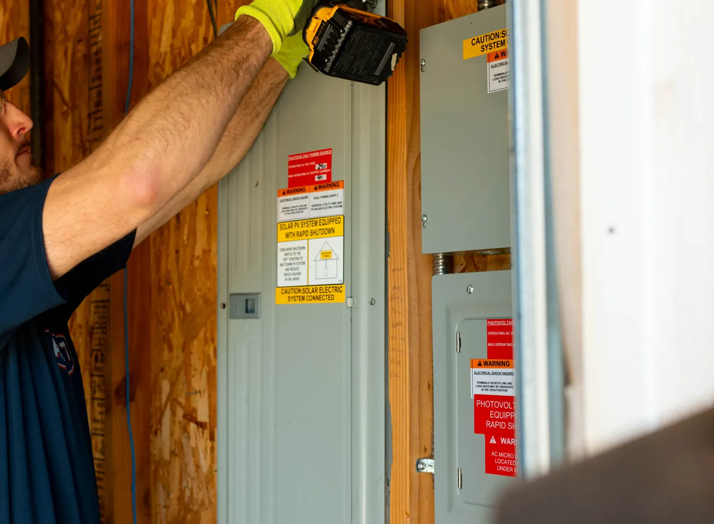 An AllSet Home electrician holding breakers in the parts room, surrounded by wiring supplies