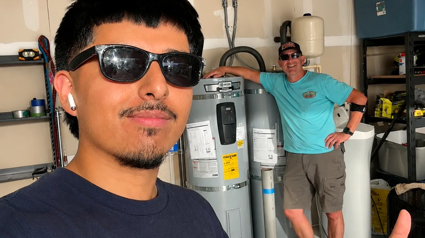An AllSet plumber and a happy customer giving thumbs up beside a newly installed water heater